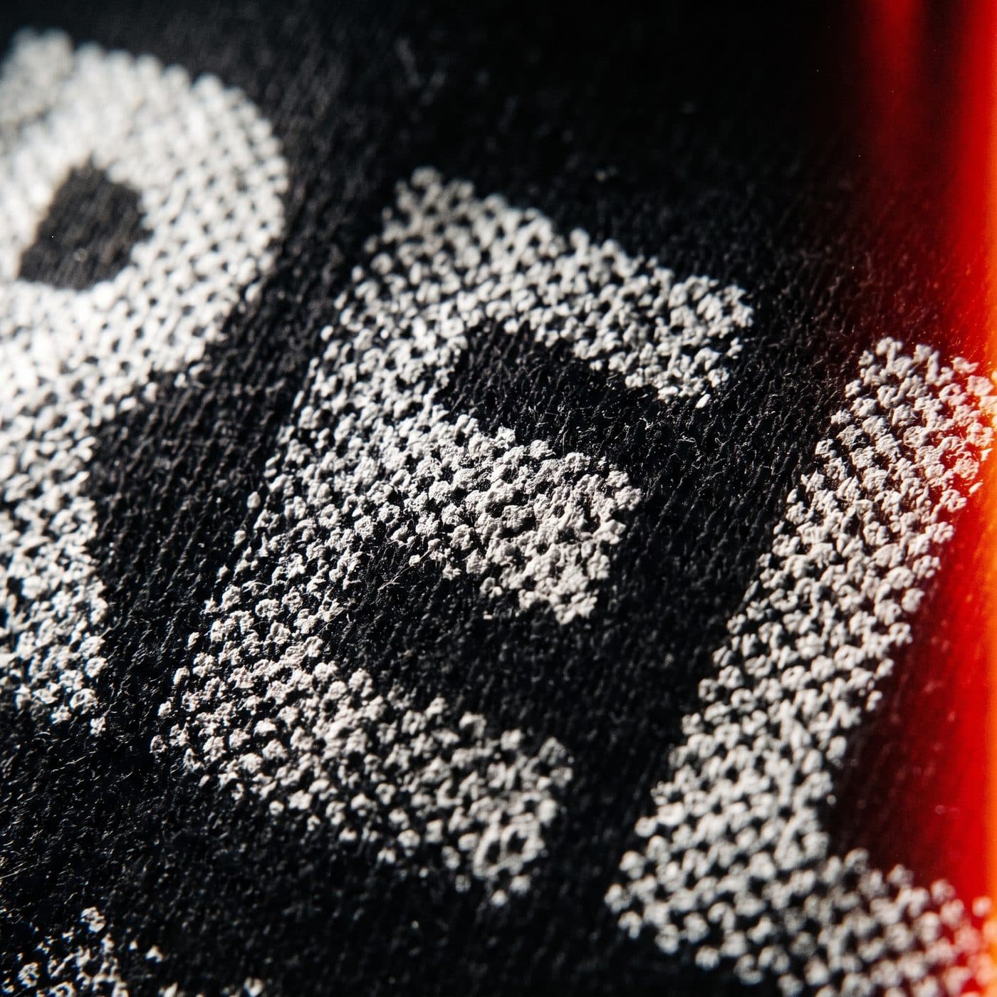 Macro of screen-printed ink on black cotton