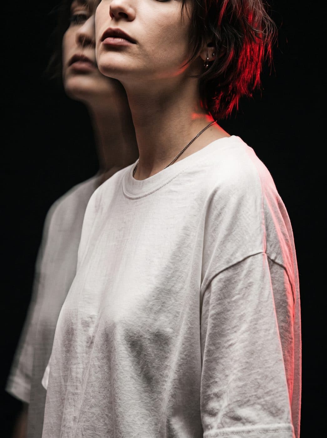 Portrait lit in red against a black backdrop